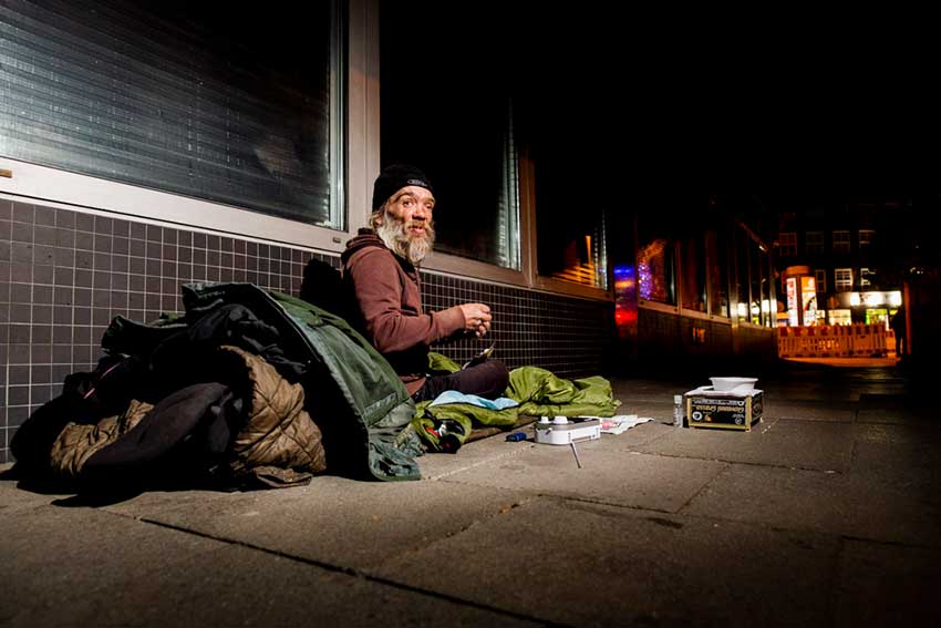 Der Obdachlose Michael hat seine Platte vor einer Hauswand aufgebaut.