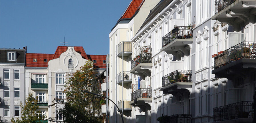 Ein weißer Altbau mit mehreren Balkons.