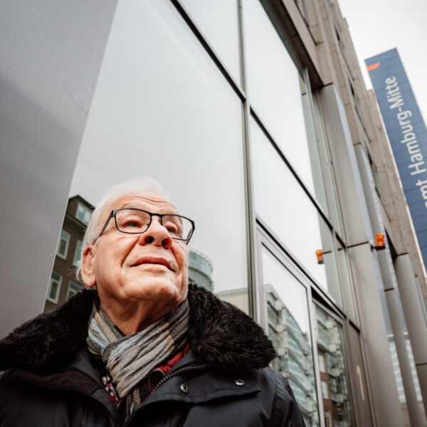Ein älterer Mann mit weißen Haaren und Brille steht vor dem Bezirksamt Mitte