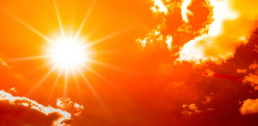 Eine hell strahlende Sonne auf orangem Hintergrund