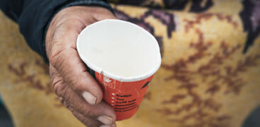 Eine Hand hält einen Pappbecher