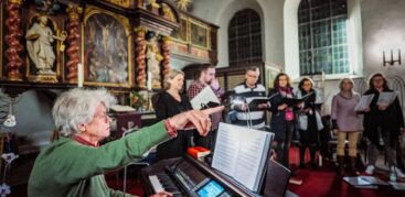 El Maestro: Michael Horn-Antoni dirigiert vom Klavier aus die Mitglieder des Chors der Kirchengemeinde Haselau. Foto: Dmitrij Leltschuk