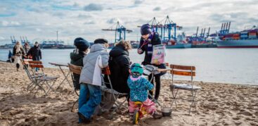 Hinz&Künztlerin Jasmin verkauft das Straßenmagazin regelmäßig am Elbstrand in Övelgönne. Foto: Dmitrij Leltschuk