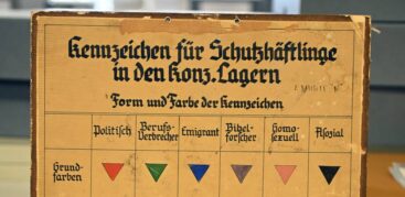 Eine vergilbte Tafel mit unterschiedlichen Zeichen, das schwarze Dreieck steht für "Asoziale"