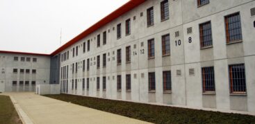 Ein graues Gebäude mit vergitterten Fenstern.