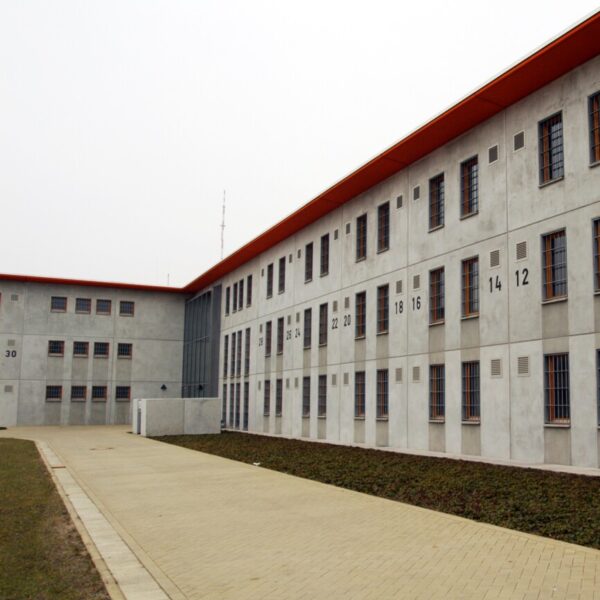 Ein graues Gebäude mit vergitterten Fenstern.