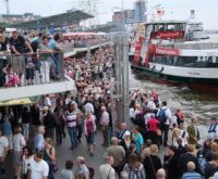 Ein Foto von den Landungsbrücken mit sehr vielen Menschen, die auf eine Fähre warten