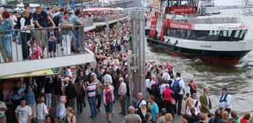 Ein Foto von den Landungsbrücken mit sehr vielen Menschen, die auf eine Fähre warten