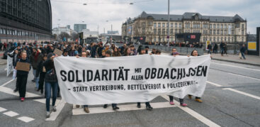 Eine Demonstratio mit einem Transparent, auf dem steht: "Solidarität mit allen Obdachlosen statt Vertreibung, Bettelverbot und Polizeigewalt"
