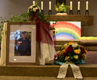 Ein Foto von Andreas neben einem Gesteck und Kerzen