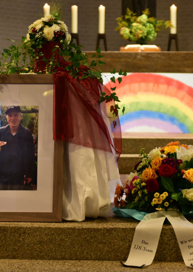 Ein Foto von Andreas neben einem Gesteck und Kerzen