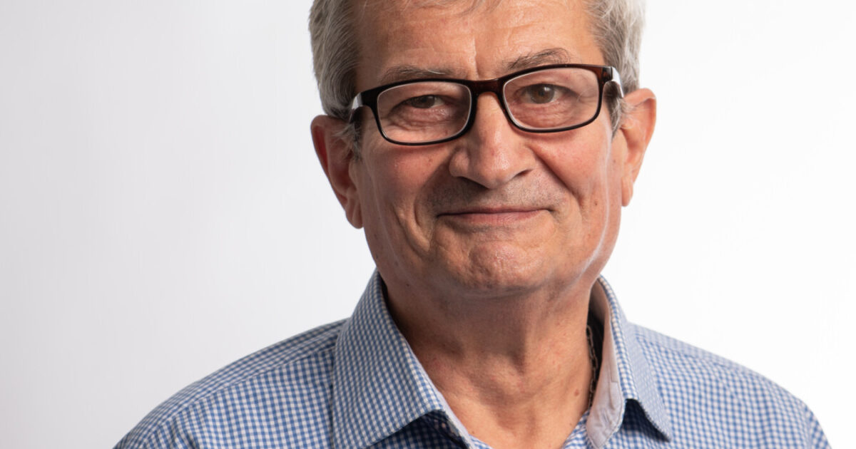 Ein gepflegt erscheinender Mann im blauen Hemd mit Brille