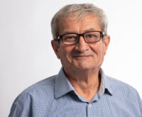 Ein gepflegt erscheinender Mann im blauen Hemd mit Brille