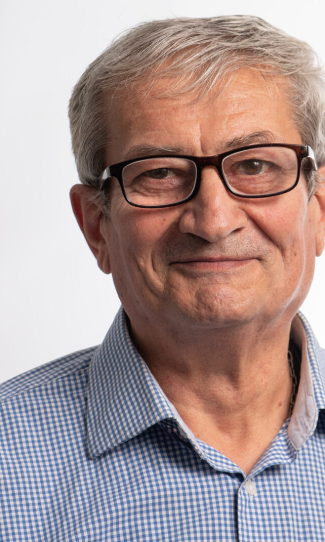 Ein gepflegt erscheinender Mann im blauen Hemd mit Brille