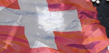 Eine Flagge der Schweiz, im Hintergrund Spritzen und Tabletten