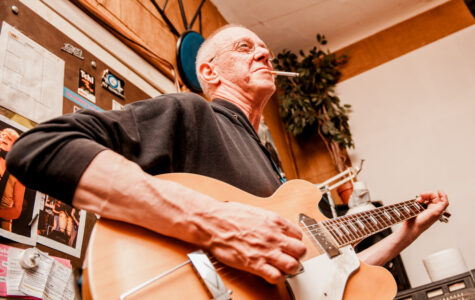 Ein Mann spielt Gitarre und raucht