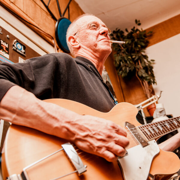 Ein Mann spielt Gitarre und raucht