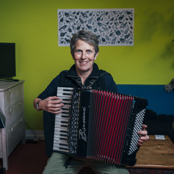 Eine Frau mit kurzen Haaren spielt auf einem Akkordeon