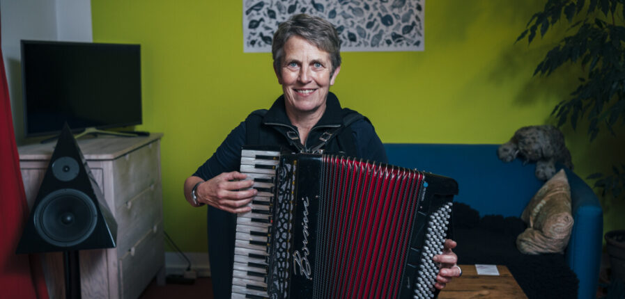 Eine Frau mit kurzen Haaren spielt auf einem Akkordeon