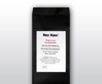 Das Bild zeigt eine schwarze Kaffeeverpackung mit einem weißen Etikett in der Mitte. Auf dem Etikett steht in roter und schwarzer Schrift "Hinz & Kunzt Espresso ¡VAMOS!". Darunter sind Details zum Kaffee aufgeführt