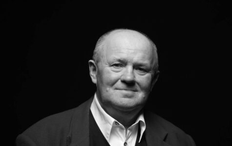 Ein Mann mit Glatze, weißem Hemd und Sakko