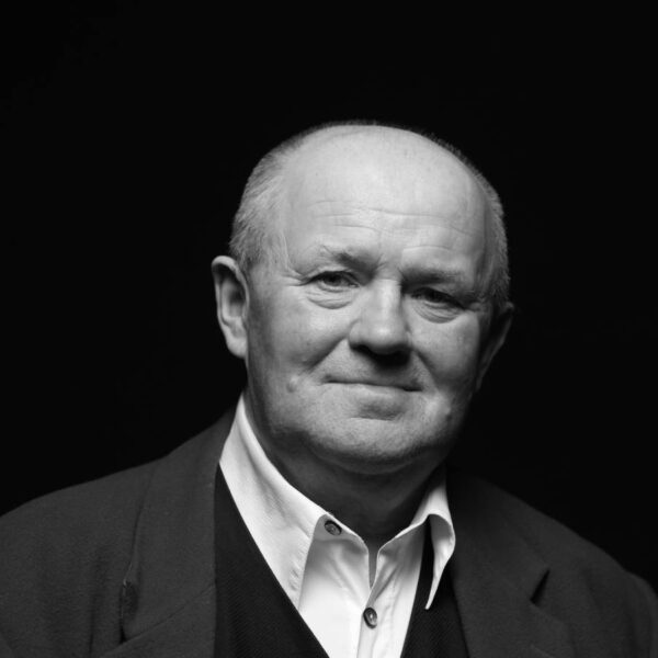 Ein Mann mit Glatze, weißem Hemd und Sakko