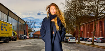 Eine Frau mit lockigen Haaren steht auf einer grünen Kiste