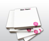 Das Bild zeigt fünf weiße aufgetürmte Hafttotizblöcke mit dem Hinz&Kinzt Logo und einem kleinen Kreis in Magenta in dem das Gründungsjahr 1993 steht