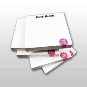Das Bild zeigt fünf weiße aufgetürmte Hafttotizblöcke mit dem Hinz&Kinzt Logo und einem kleinen Kreis in Magenta in dem das Gründungsjahr 1993 steht
