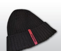 Die Abbildung zeigt eine dunkelblaue Strickmütze mit einem magentafarbenen Etikett, auf dem in schwarzer Schrift "Hinz&Kunzt" steht.