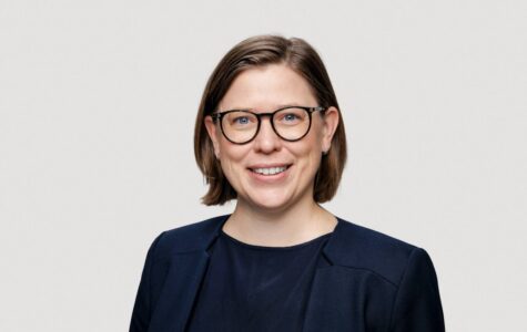 Eine Frau in dunkelblauem Sacko lächelt freundlich in die Kamera