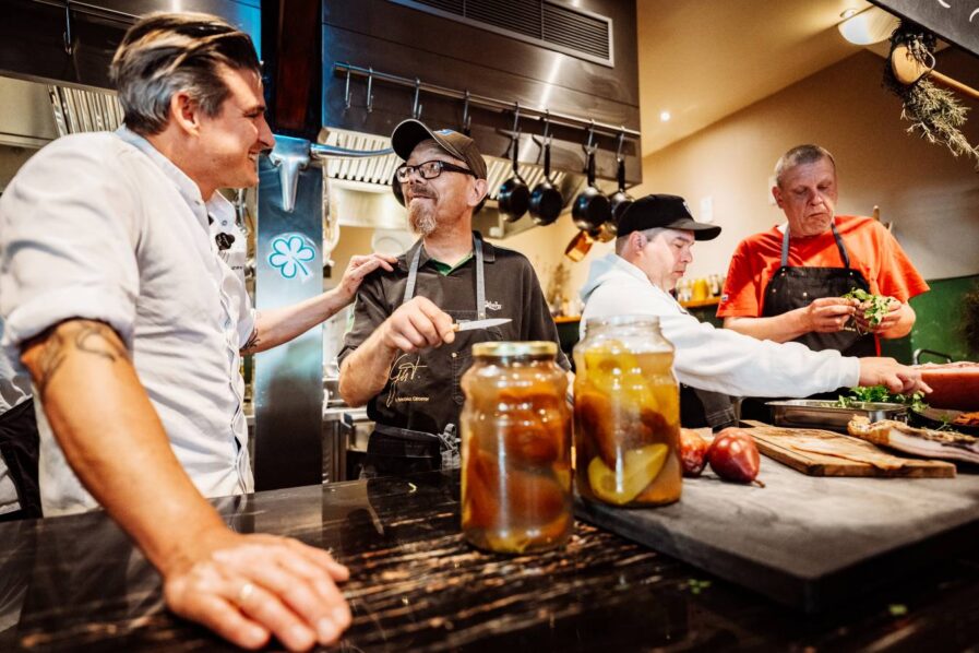 Vier Männer werkeln in einer Küche
