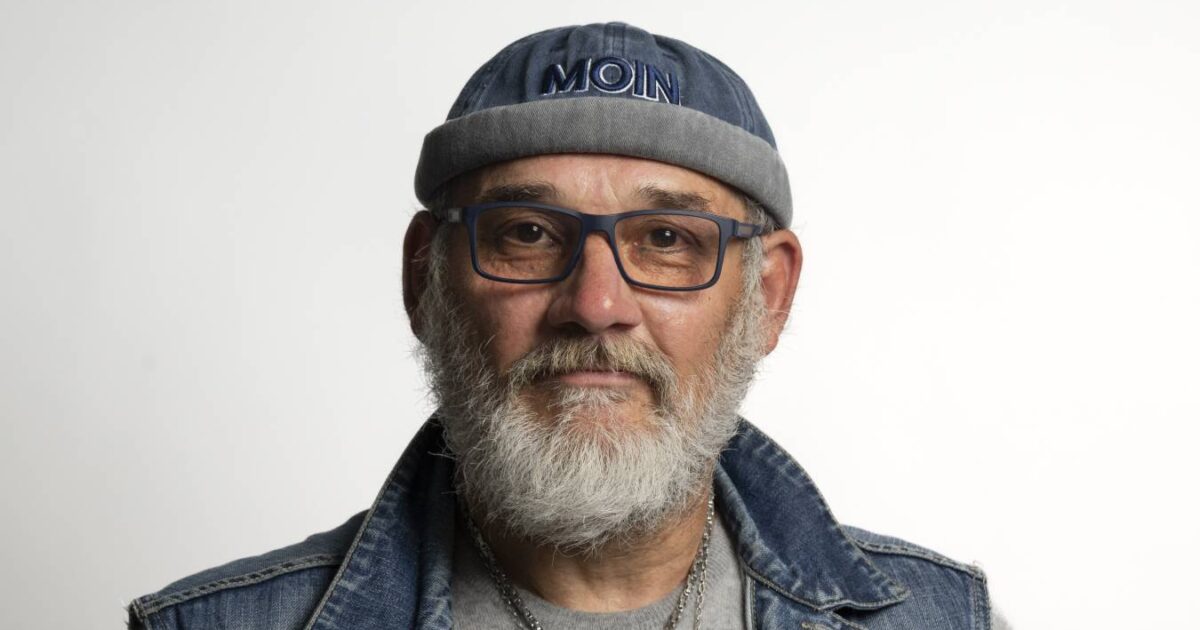 Ein Mann mit grauem Bart, Brille und einer Mütze mit der Aufschrift "Moin"