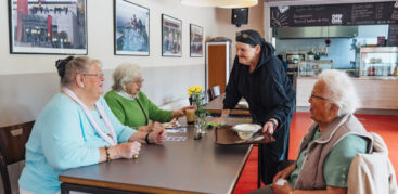 Drei Seniorinnen essen im Café Osborn zu Mittag.