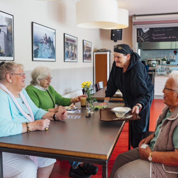 Drei Seniorinnen essen im Café Osborn zu Mittag.