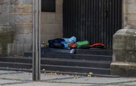 Schlafsäcke und Isomatten liegen auf einer Steintreppe vor einer Kirchentür