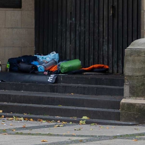 Schlafsäcke und Isomatten liegen auf einer Steintreppe vor einer Kirchentür
