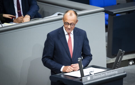 Ein Mann im dunkelblauen Anzug mit rot-weiß gemusterter Krawatte steht am Rednerpult des Bundestags