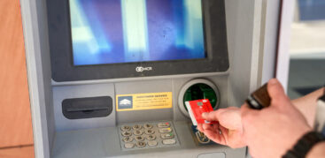 Jemand steckt eine EC-Karte in einen Geldautomaten