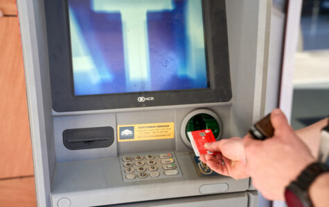 Jemand steckt eine EC-Karte in einen Geldautomaten