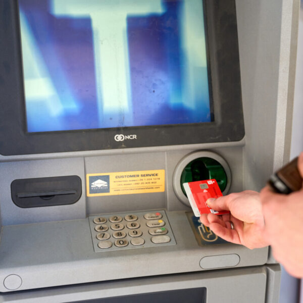 Jemand steckt eine EC-Karte in einen Geldautomaten