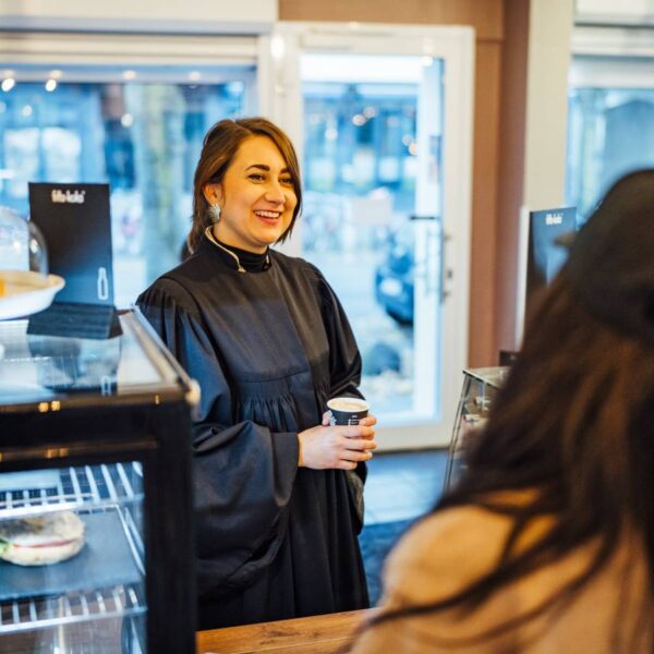 Im Talar im Lieblingscafé: Pastorin Rebecca Assif. Foto: Miguel Ferraz