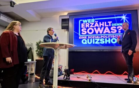 Ein großer Bildschirm mit der Aufschrift "Wer erzählt denn sowas? Eine sozialpolitische Quizshow"