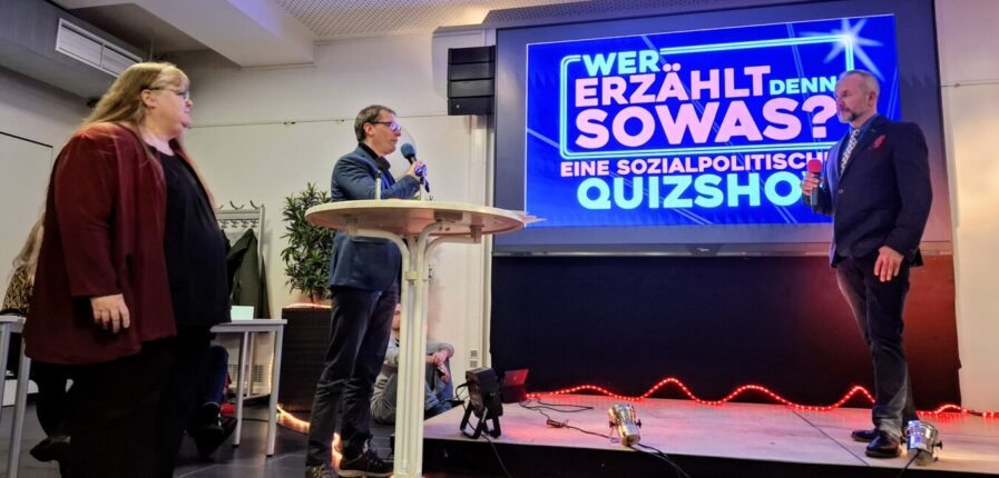 Ein großer Bildschirm mit der Aufschrift "Wer erzählt denn sowas? Eine sozialpolitische Quizshow"