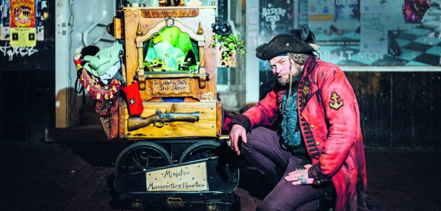 Straßenkünstler Joshua zieht mit seinem Miniatur Marionettentheater durch Fußgängerzonen. Foto: Miguel Ferraz