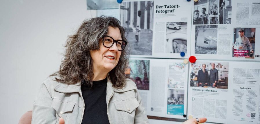 Eine Frau mit dunklen Haaren und dunkler Brille gestikuliert beim Sprechen