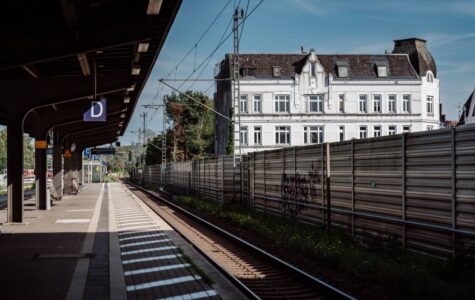 Ein weißes Haus von einem Bahnsteig aus fotografiert.