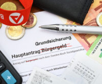 Ein Antrag auf Bürgergeld, auf dem das Wort "Bürgergeld" durchgestrichen ist. Darüber steht "Grundsicherung".