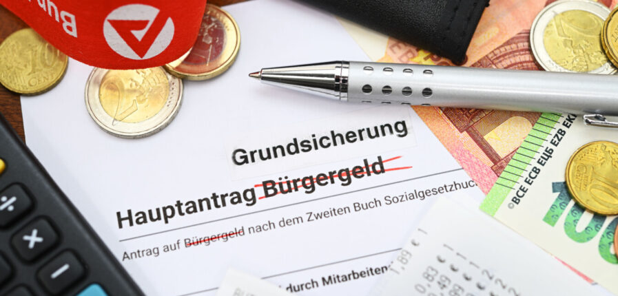Ein Antrag auf Bürgergeld, auf dem das Wort "Bürgergeld" durchgestrichen ist. Darüber steht "Grundsicherung".