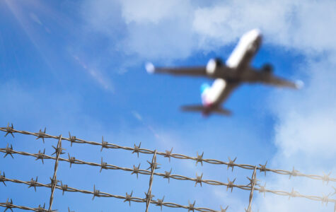Ein Flugzeug fliegt über Stacheldraht